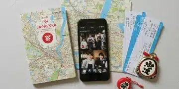 Travel guide, map, phone with J-drama scene, plane tickets, and charm for Japanese drama tourism planning.